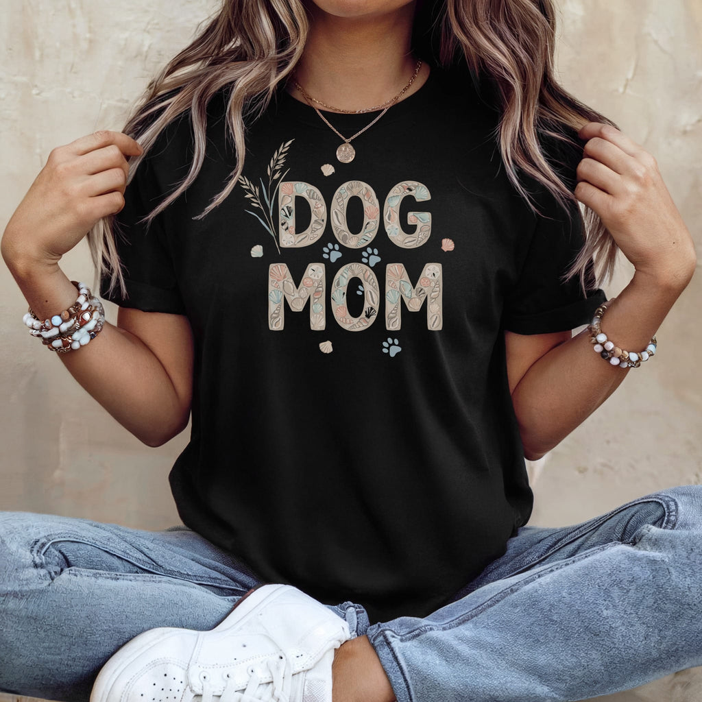 Black t-shirt with "DOG MOM" text in seashell pattern and paw prints.