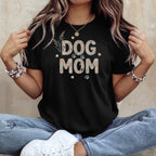 Black t-shirt with "DOG MOM" text in seashell pattern and paw prints.