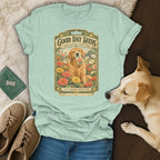 A mint green t-shirt featuring a vintage seed packet graphic with a golden retriever holding a zinnia packet.