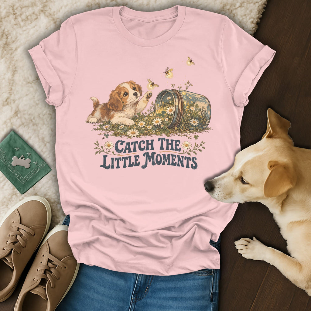 Pink t-shirt with a puppy graphic and the text Catch the Little Moments, surrounded by casual items.
