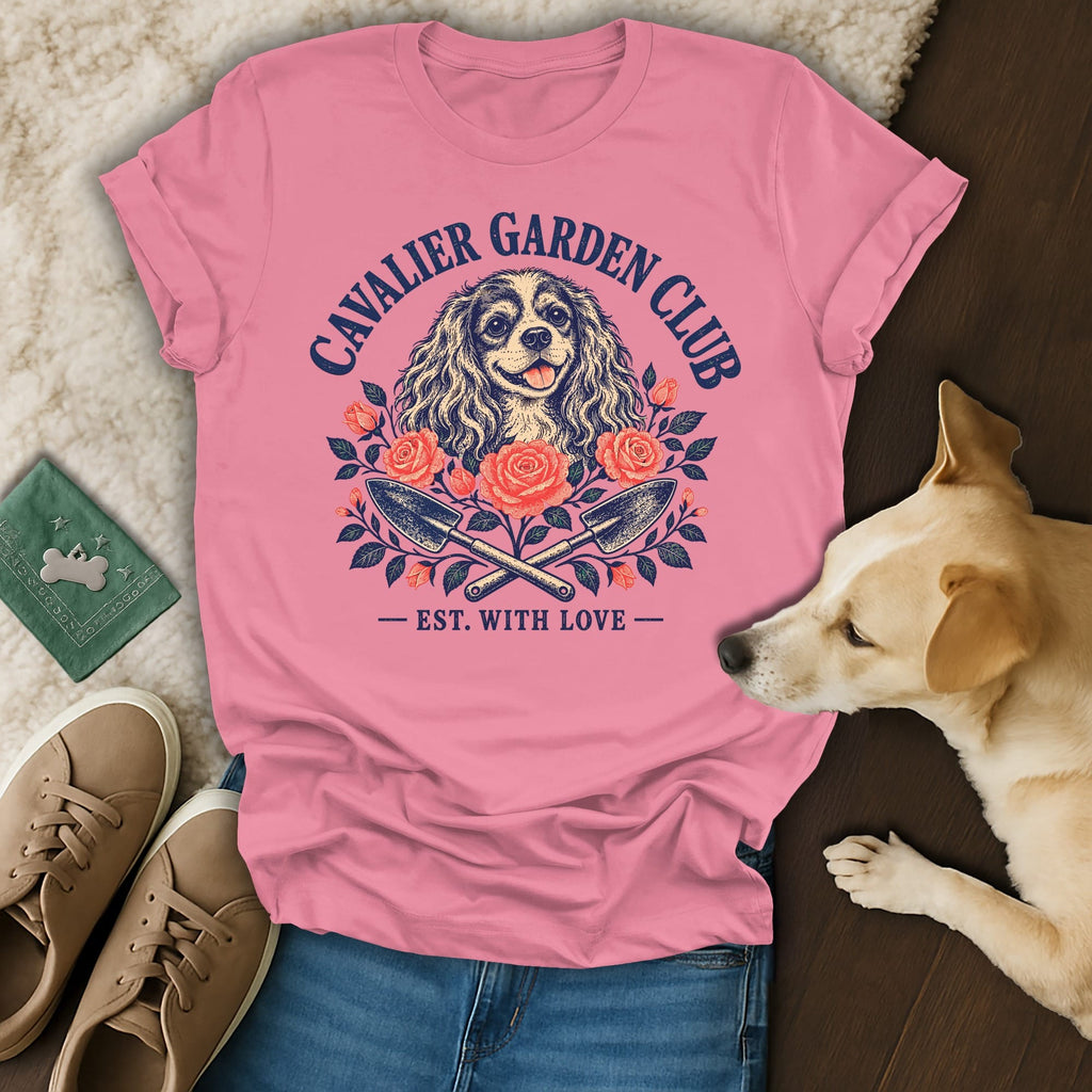 Pink t-shirt featuring a Cavalier King Charles Spaniel graphic, garden tools, and text reading Cavalier Garden Club.