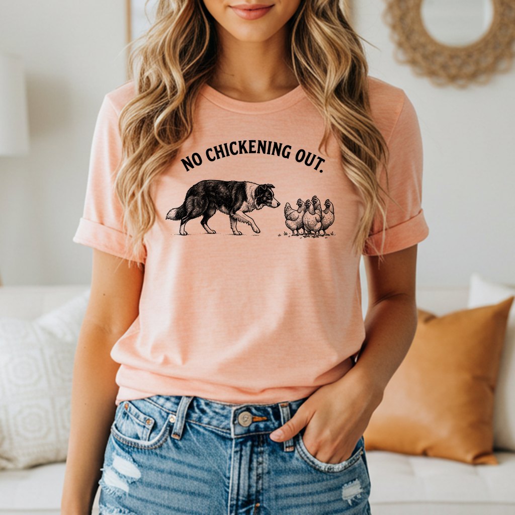 Peach t-shirt with black graphic of dog facing chickens and text "NO CHICKENING OUT."