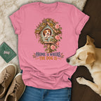 Pink t-shirt with a graphic of a dog in a floral birdhouse and the text "Home is Where the Dog Is".