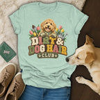 Sage green t-shirt featuring a goldendoodle graphic and the text Dirt and Dog Hair Club.