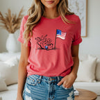 Dog rolling with American flag on a red t-shirt.