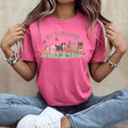 Pink t-shirt with cartoon dogs and butterflies, reads "Paws in Bloom."