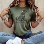Green t-shirt with a stylized dog design and text "Happiness Has Four Paws".
