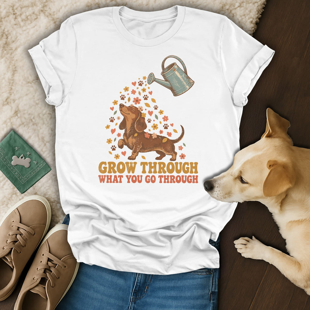 White t-shirt featuring a dachshund graphic with flowers, a watering can, and the text Grow Through What You Go Through.