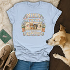Light blue t-shirt featuring a graphic of four dogs on a bench, surrounded by text reading Mimi's Granddogs.