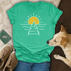 Teal t-shirt with a minimalist sunset and dog on a pier graphic.