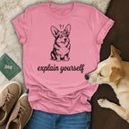 Pink t-shirt with a cartoon corgi and text "explain yourself".