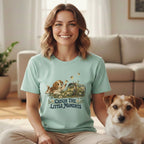 A smiling woman wearing a mint-green t-shirt with a graphic of a puppy and the text "Catch the Little Moments," sitting beside a small terrier in a living room.