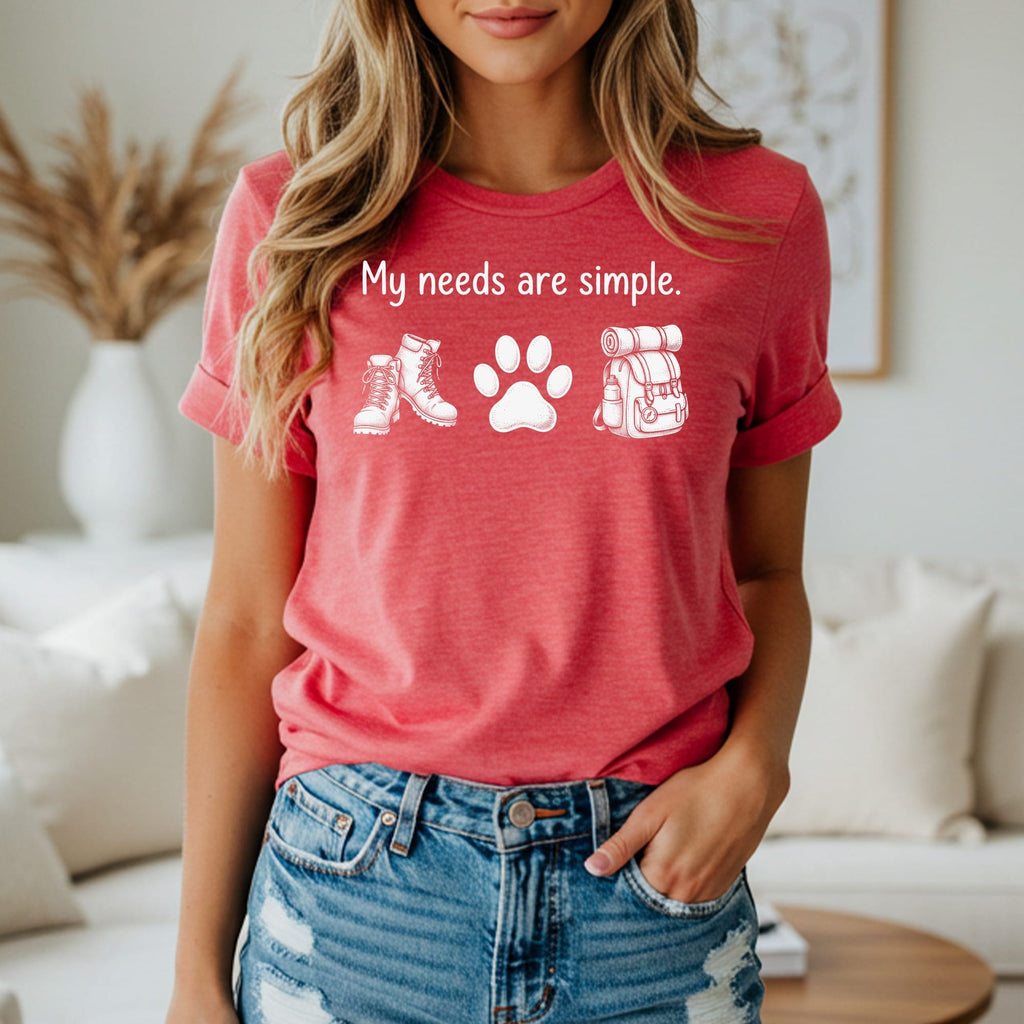 Red t-shirt with white graphic of boots, paw print, and backpack with text "My needs are simple."
