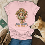 A pink t-shirt featuring a graphic of a dog in a birdhouse with the text Home Is Where The Dog Is.