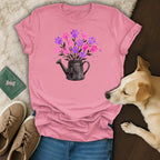 Pink t-shirt with a black watering can and paw print flowers.