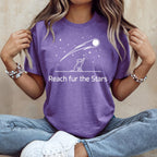 Purple t-shirt with dog reaching for a shooting star, "Reach fur the Stars" text.