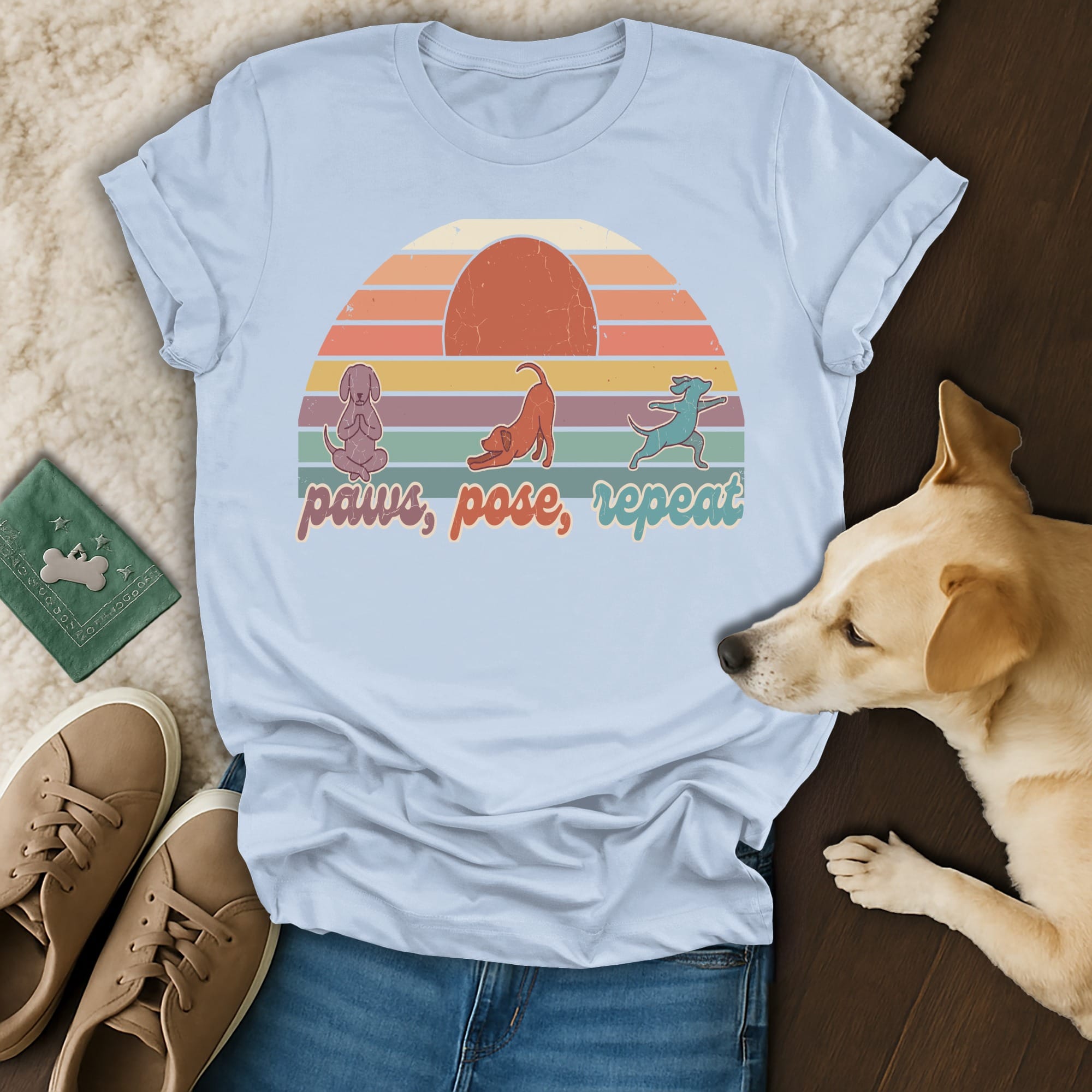 Light blue t-shirt with a retro sunset graphic and yoga-posing dogs, reading "paws, pose, repeat."