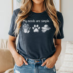 T-shirt with text "My needs are simple" and icons of gardening, paw print, and hat.
