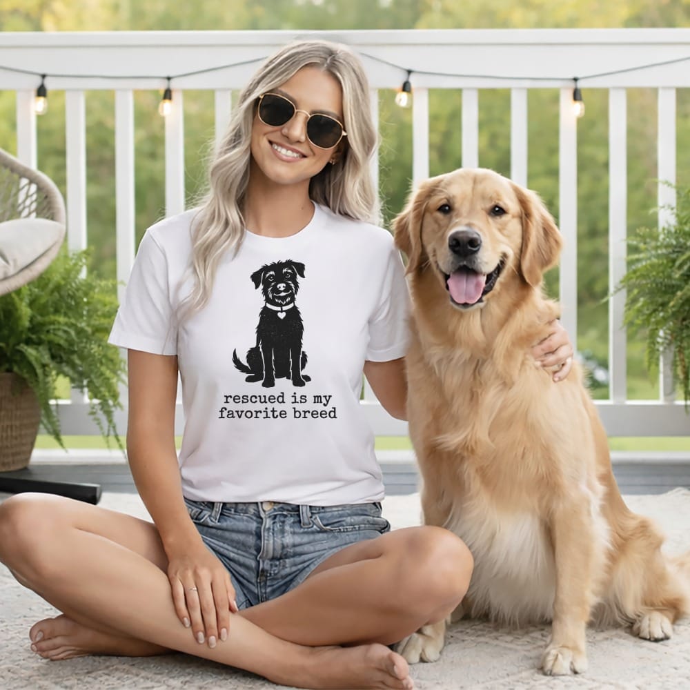 Woman wearing a t-shirt with a dog graphic and "Rescued is my favorite breed" text.