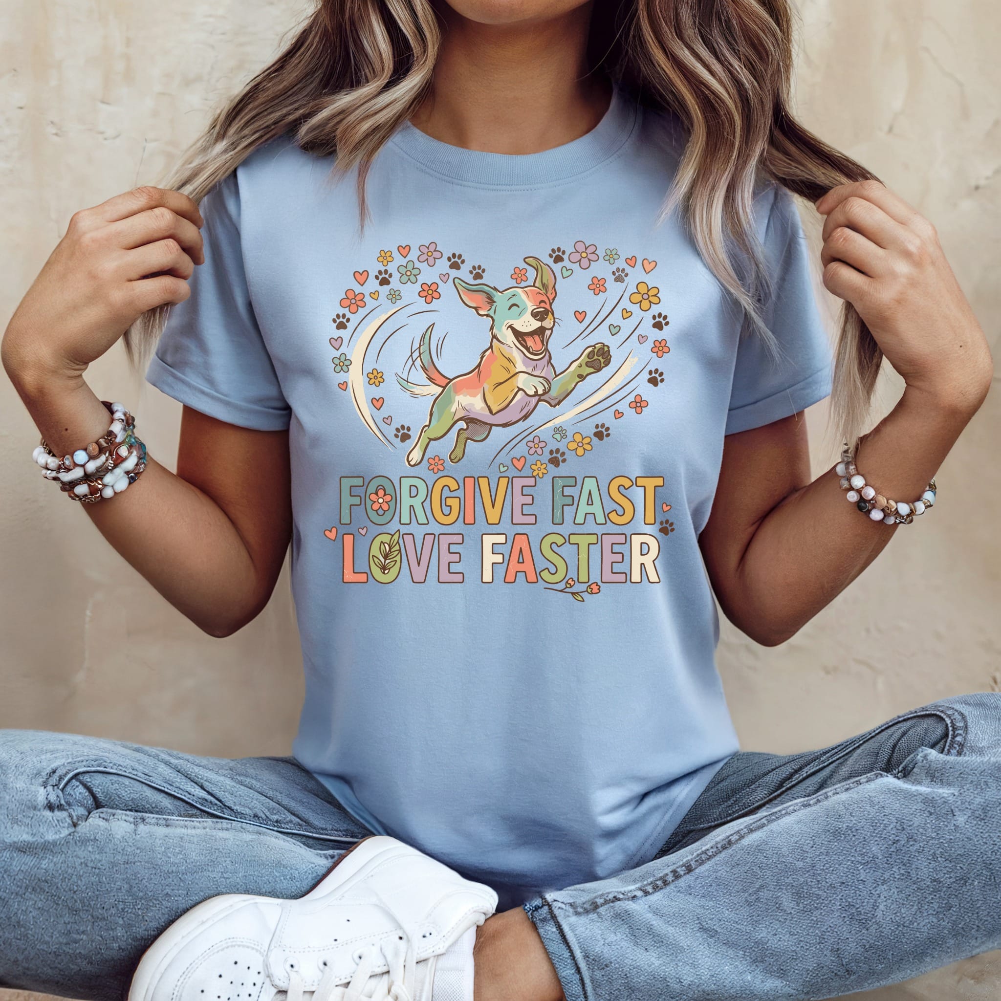 Light blue t-shirt with colorful dog graphic and text "FORGIVE FAST LOVE FASTER".