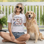 Woman in "Celebrating 250 Pawtriots Since 1776" shirt with golden retriever.