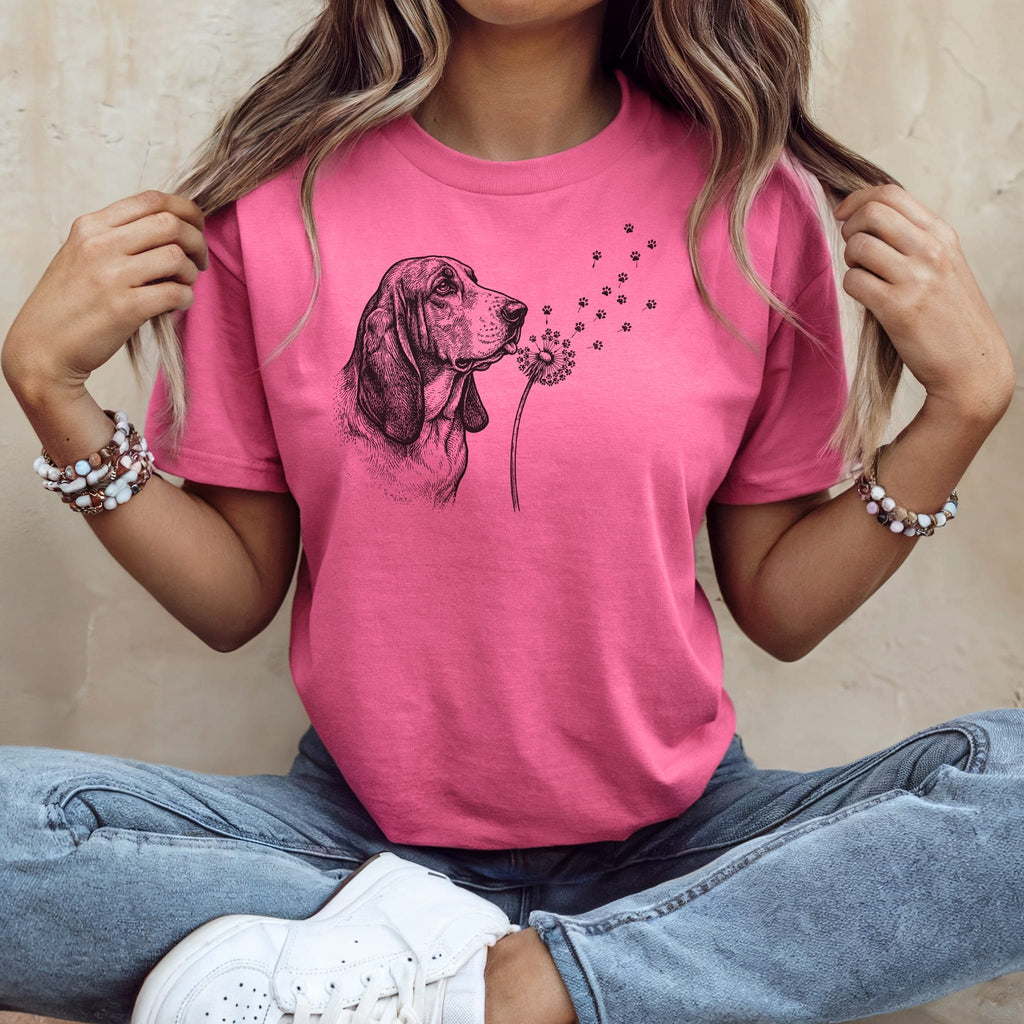 Pink t-shirt with a black line drawing of a Basset Hound blowing dandelion seeds.
