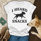 White t-shirt with black silhouette of a running dog and text "I HEARD SNACKS".