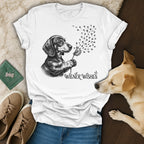 White t-shirt with dachshund holding a dandelion that turns into paw prints, "Wiener Wishes" text.