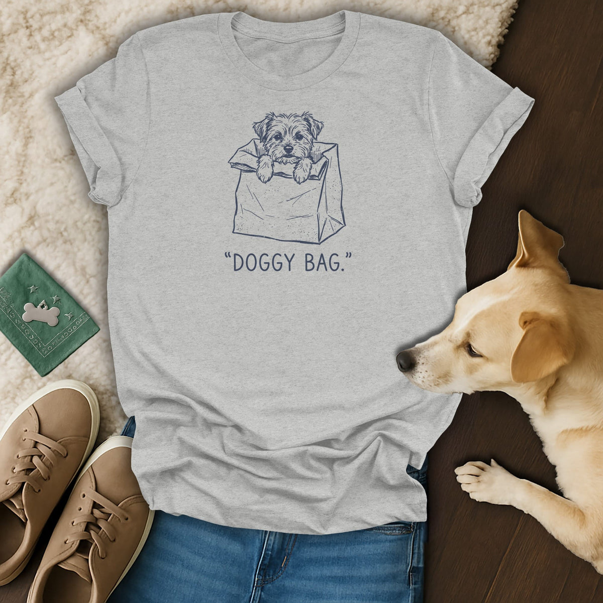 Grey t-shirt with a graphic of a dog in a bag and the text "DOGGY BAG."