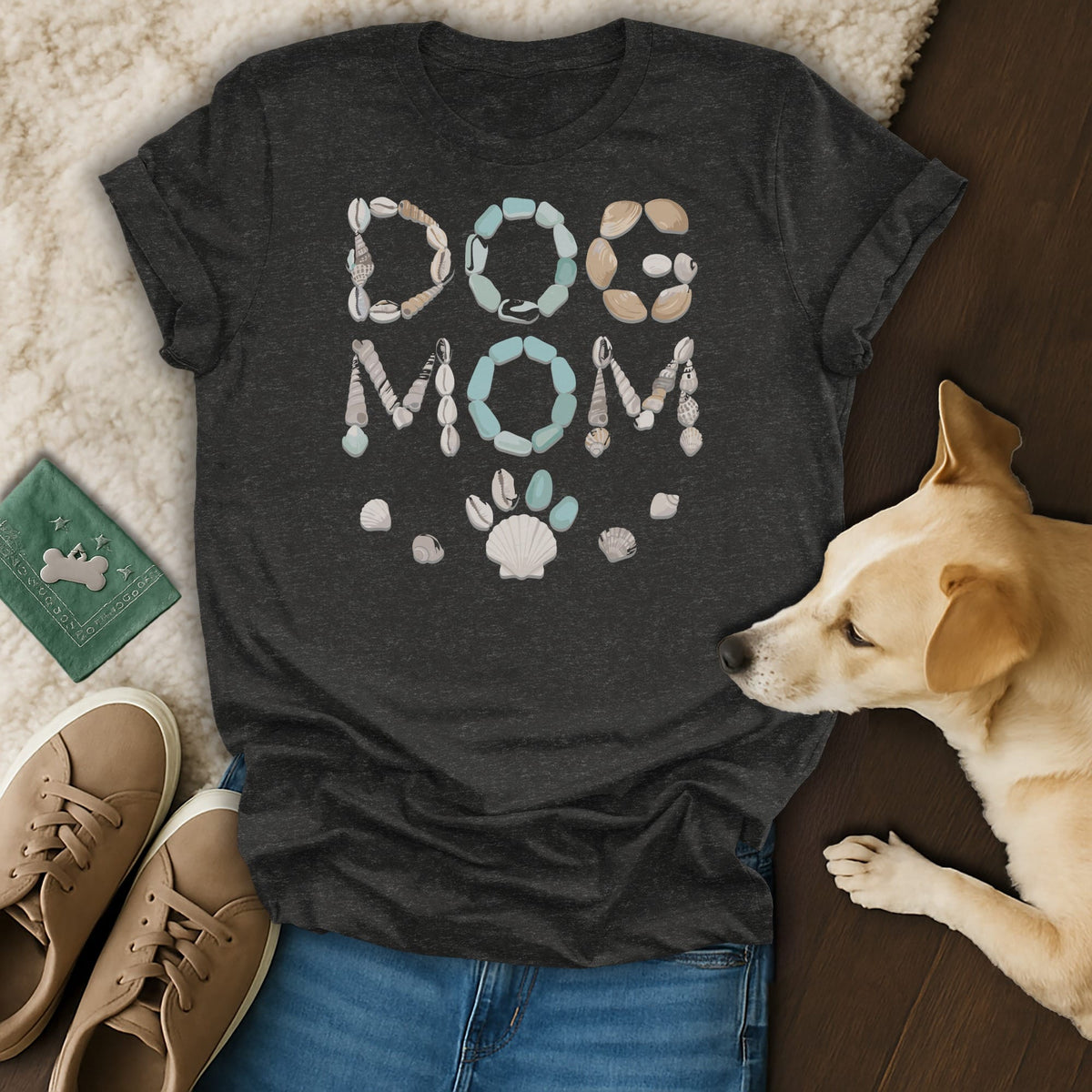 Dark grey t-shirt with "DOG MOM" text made of shells and a seashell paw print.