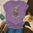 Purple t-shirt with a doodle dog wearing a beanie graphic, flat lay.