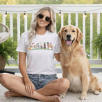 Woman wearing a t-shirt with cartoon dogs, sitting with a golden retriever.
