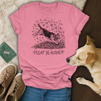 Pink t-shirt with beagle jumping into leaves graphic and "Leaf Me Alone" text.