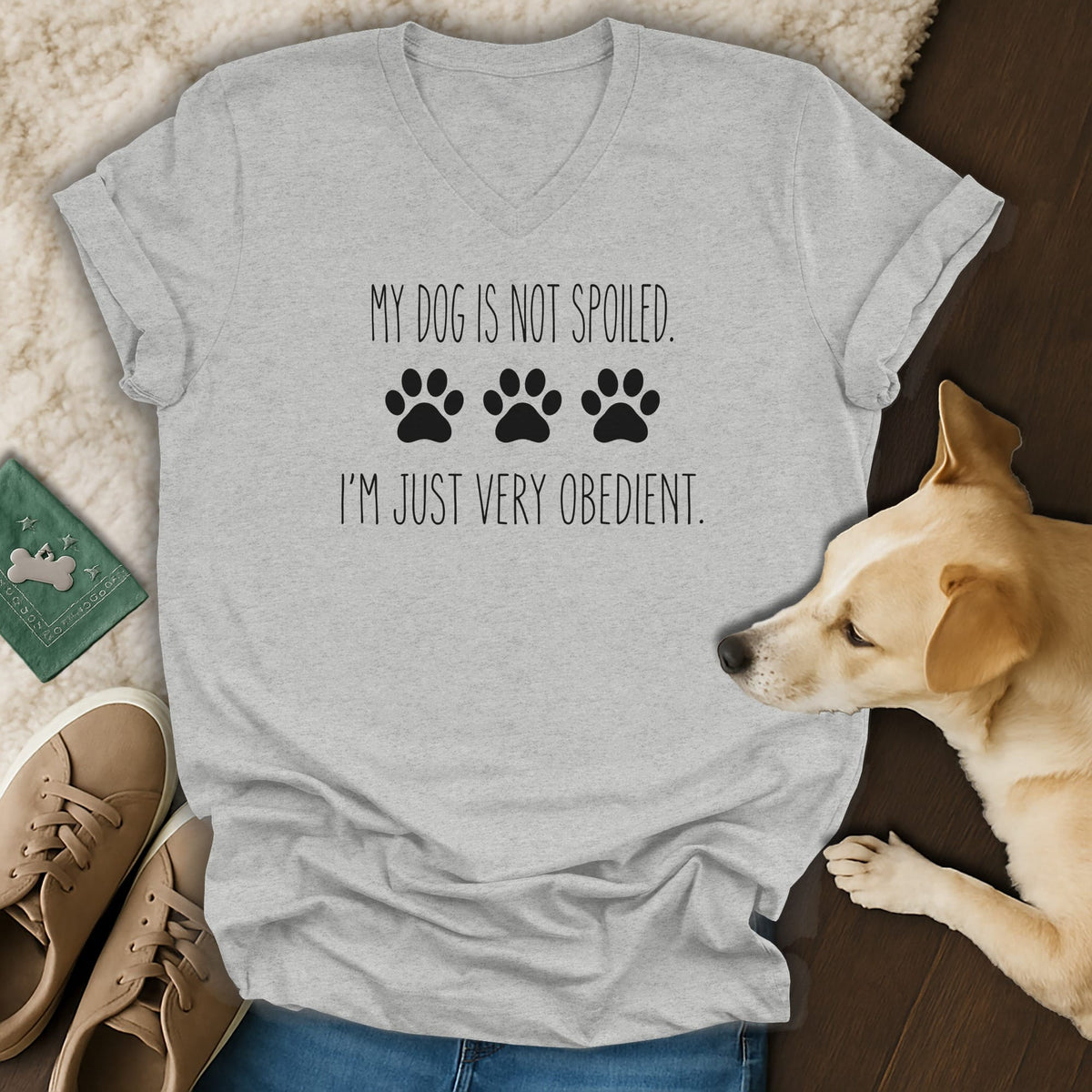 Grey v-neck t-shirt with "My dog is not spoiled. I'm just very obedient." text and paw prints.