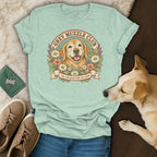 Sage green t-shirt featuring a retro golden retriever illustration with flowers and the text Grey Muzzle Club.