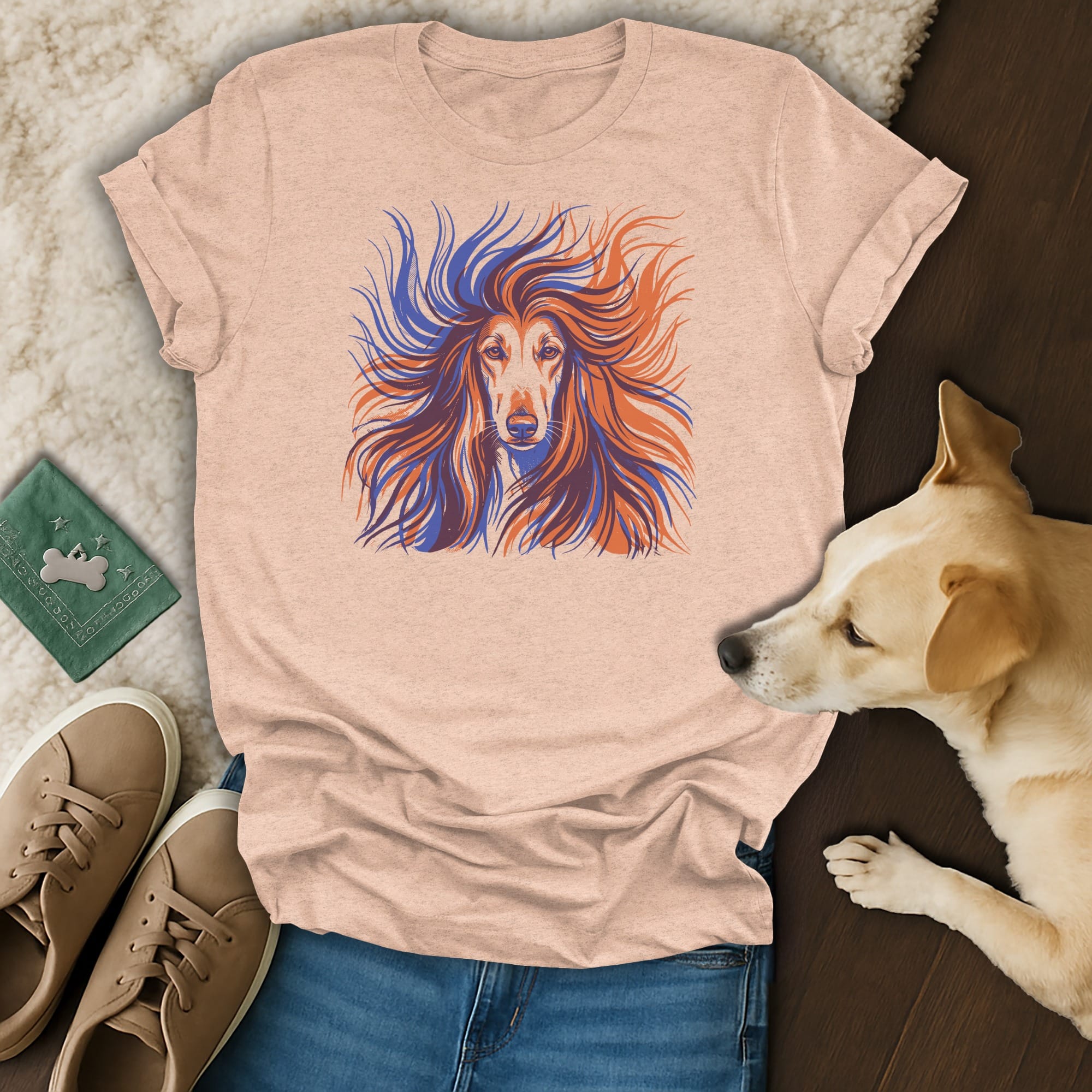 Graphic tee with abstract Afghan Hound face design, laid flat with dog.