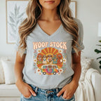 Retro t-shirt graphic "WOOF STOCK" with dogs playing music in a tie-dye van.