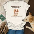 White t-shirt with text "I'M TRYING TO BE MORE SOCIAL" and a dog holding a teacup.
