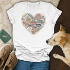 White t-shirt with embroidered heart of dog toys, paws, bones, and flowers.