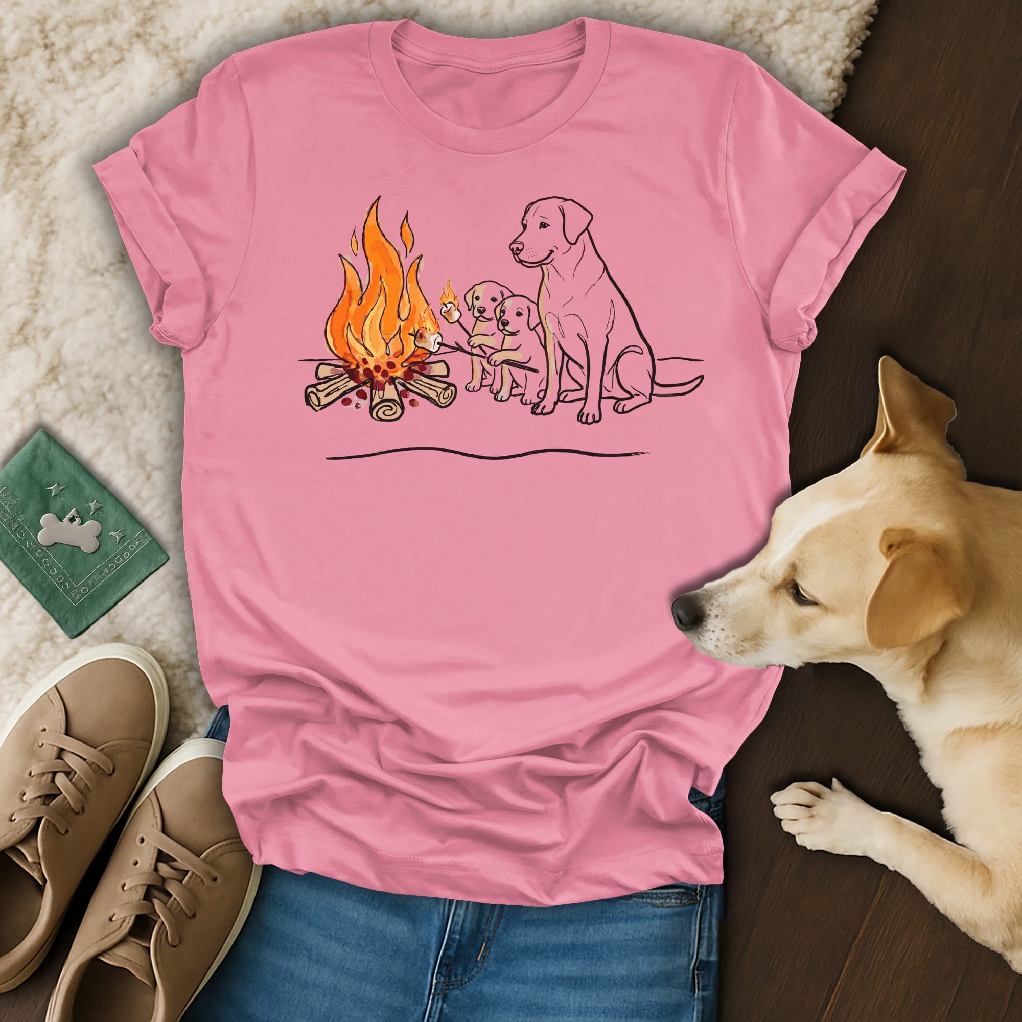 Two labrador puppies roast marshmallows by a campfire, with an adult labrador watching.