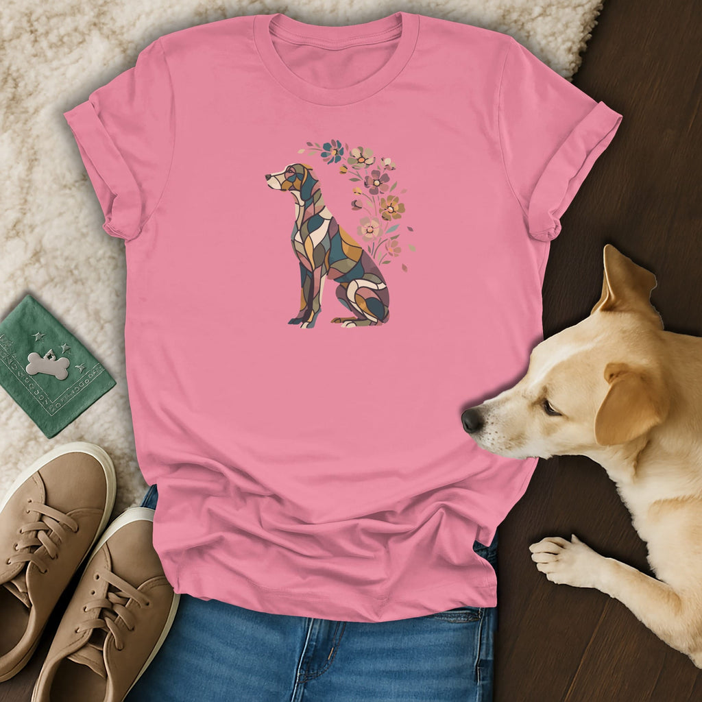 A pink t-shirt with a mosaic dog graphic is displayed with jeans, sneakers, and a sleeping dog.