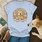 A light blue t-shirt printed with a golden retriever graphic and the text Grey Muzzle Club.