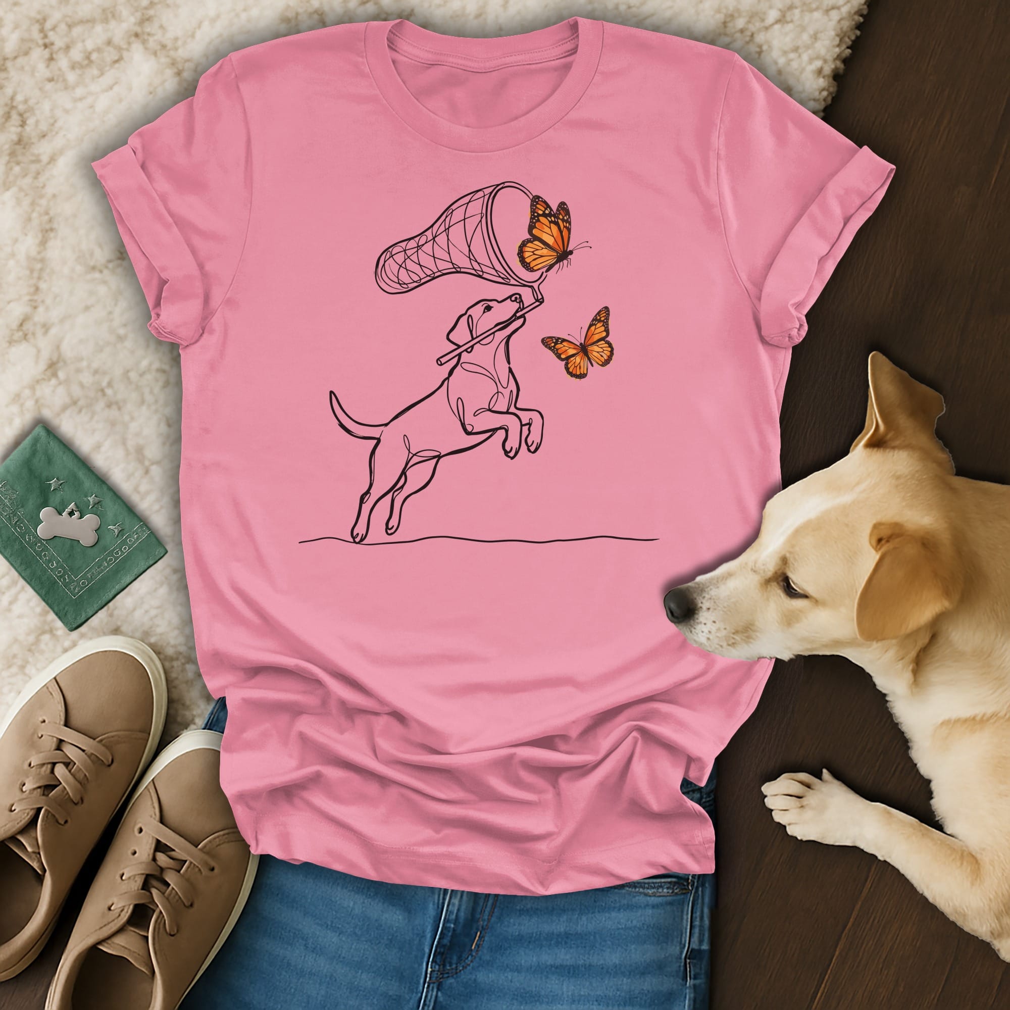 Line drawing of a dog catching butterflies with a net on a pink t-shirt.