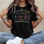 Black t-shirt with "April Showers Brings Paw Flowers" text and colorful paw prints.