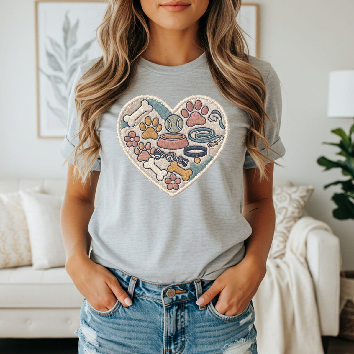 Grey t-shirt with embroidered heart of dog toys, paws, bones, and flowers.