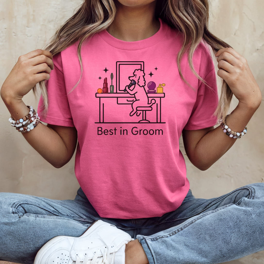 Woman wearing pink t-shirt with "Best in Groom" text and illustration of dog at vanity.