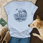 Golden retriever surfing a wave in a stylized blue line drawing on a light blue t-shirt.