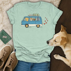 Light blue t-shirt with cartoon dogs in a van, travel accessories, and red hearts.