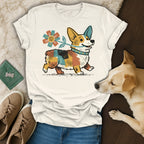 Corgi with flower on shirt, accompanied by dog and sneakers.