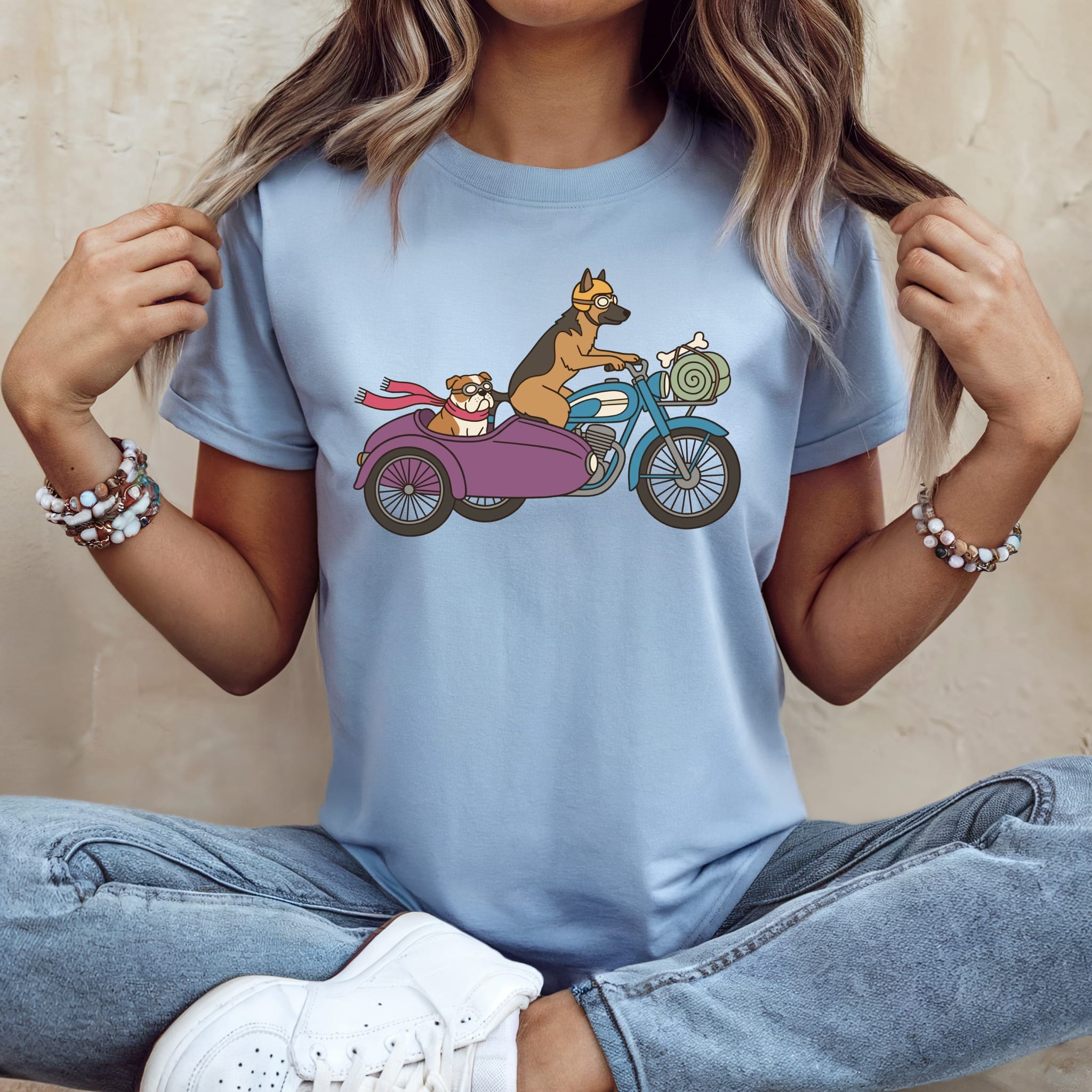 German Shepherd driving motorcycle with Bulldog in sidecar, wearing goggles and scarves.